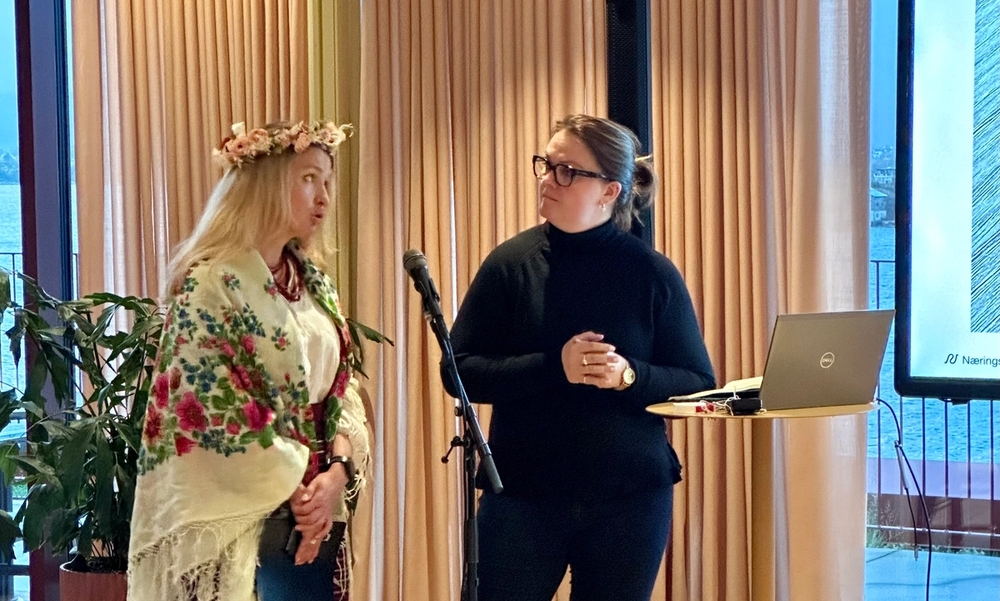 To kvinner står og holder et innlegg