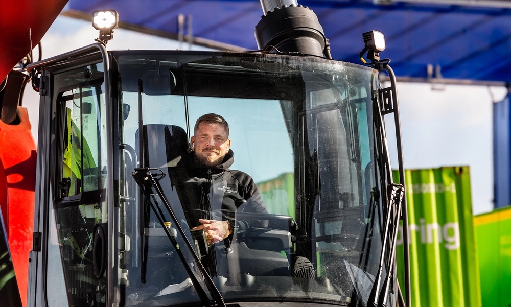 Mann sitter i en traktor