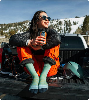 Woman wearing Darn Tough socks in the bed of a truck