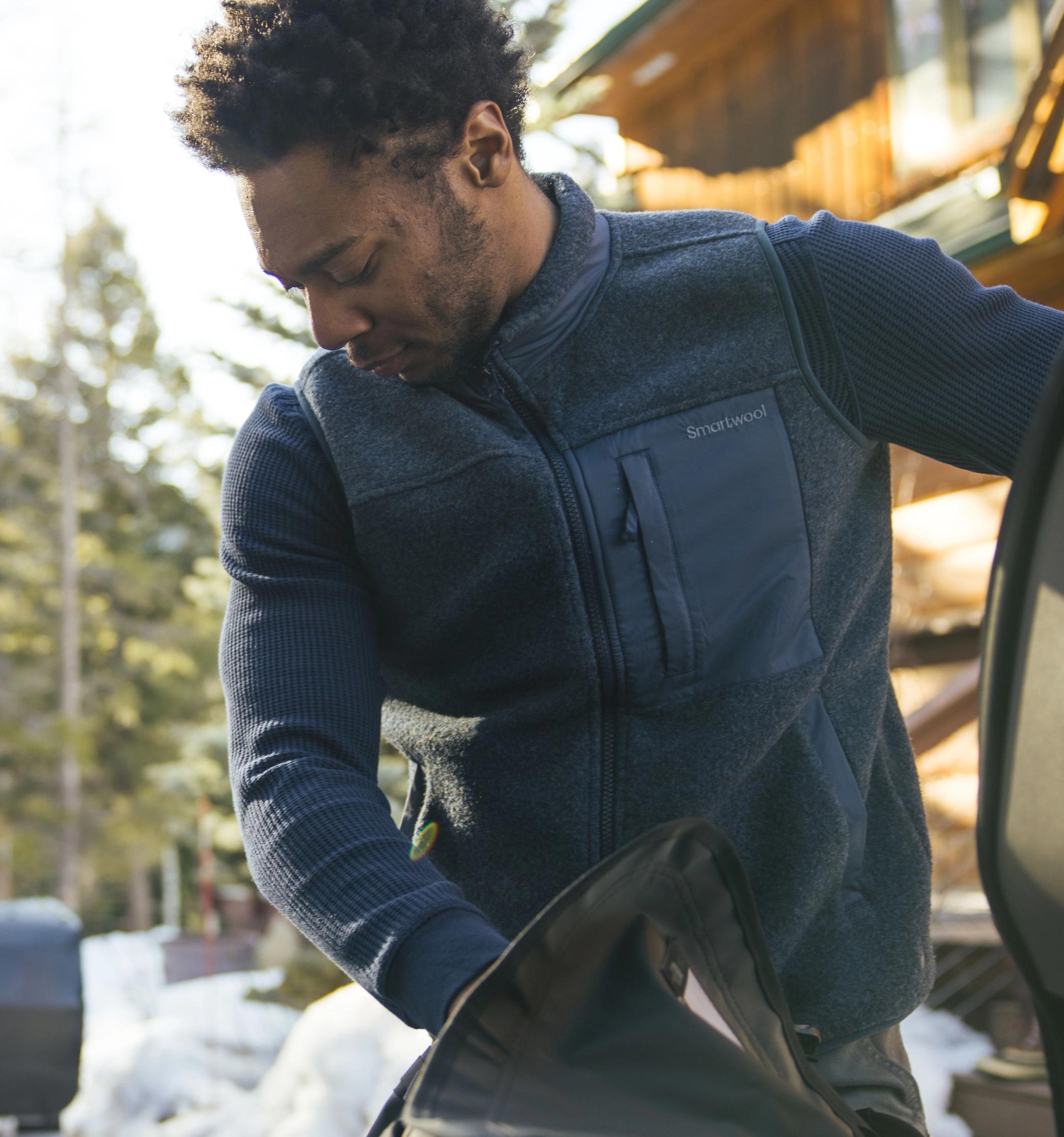 Homme dans la neige portant des vêtements Smartwool