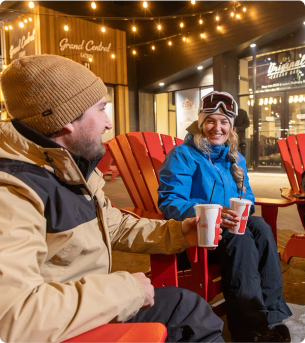 A man and a woman in snow gear drinking Coca Cola