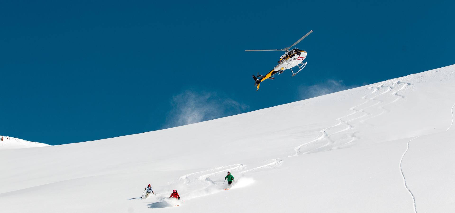 Group of people skiing and riding with Mike Wiegele Helicopter Skiing