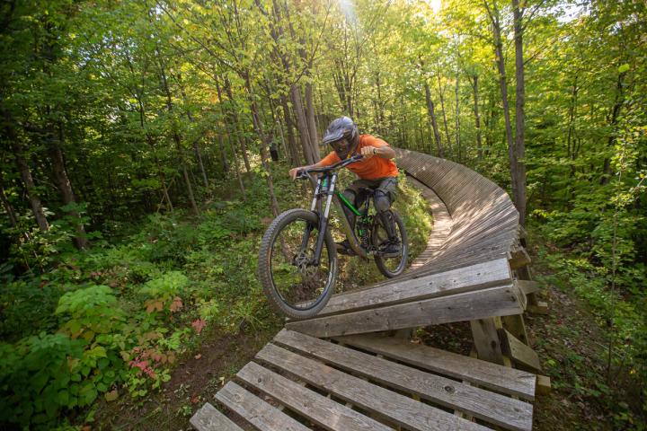 Person on mountain bike going down a wooden planked trail