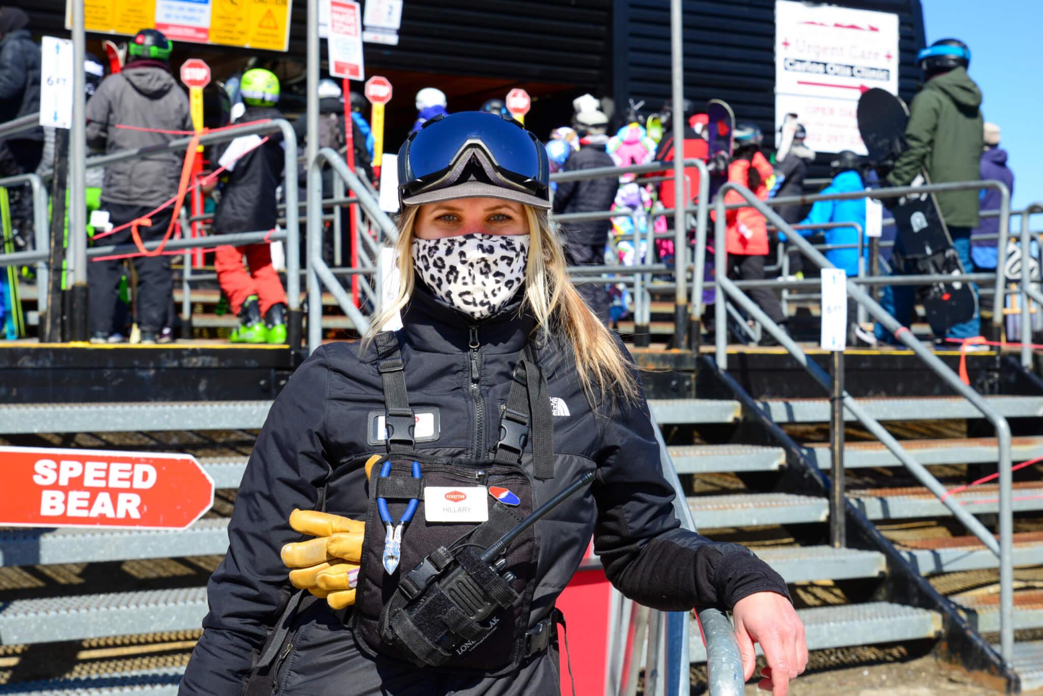 Adult wearing a face mask wearing winter gear looking at the camera
