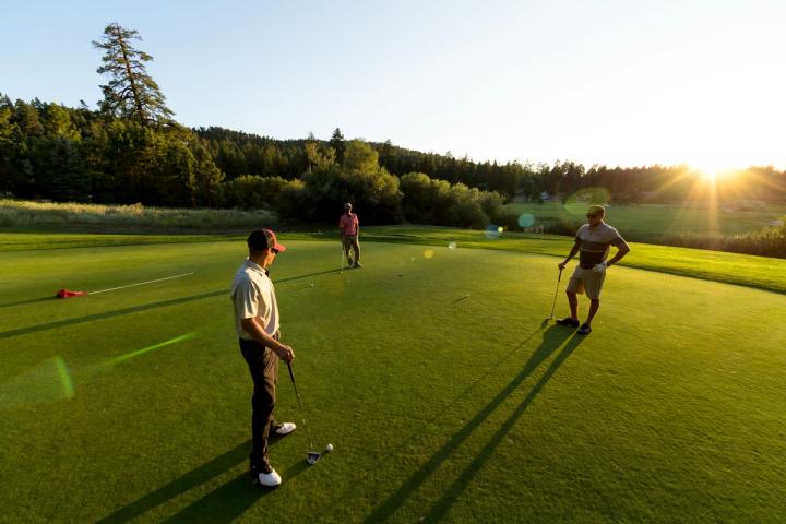 A group of people standing on a golf course
