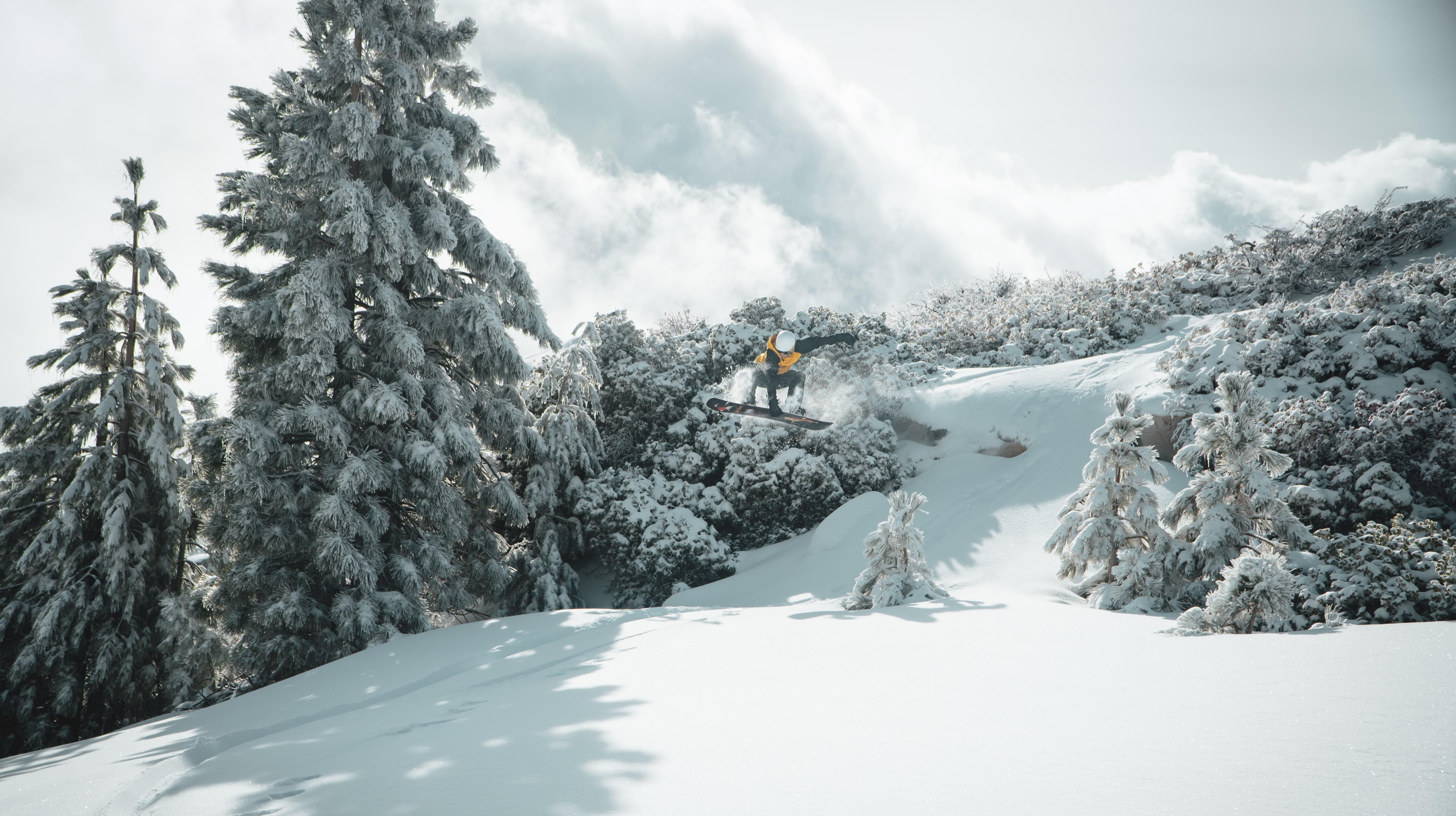 Snowboarder doing a jump on a snowy slope