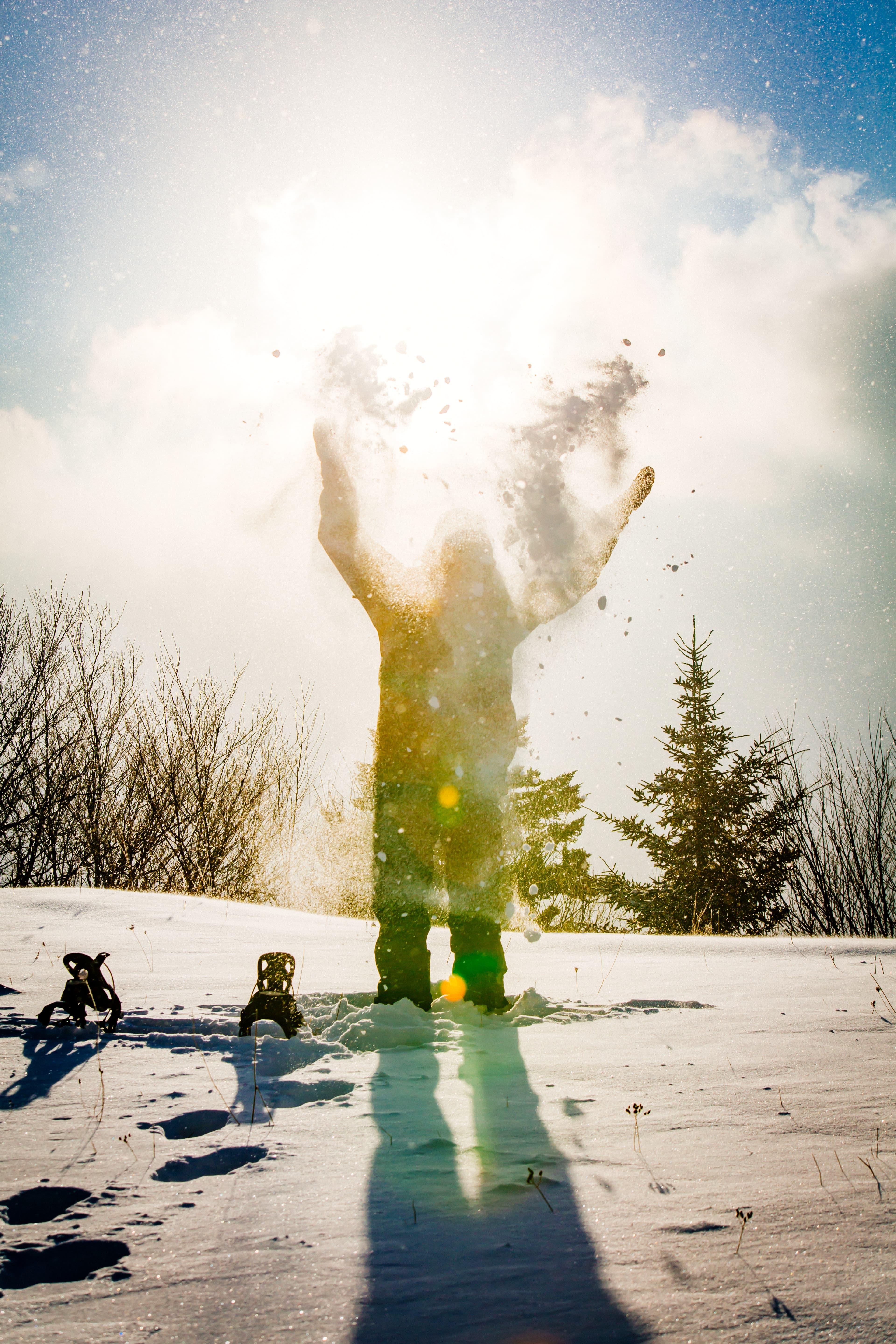 Persons throwing snow up in the air