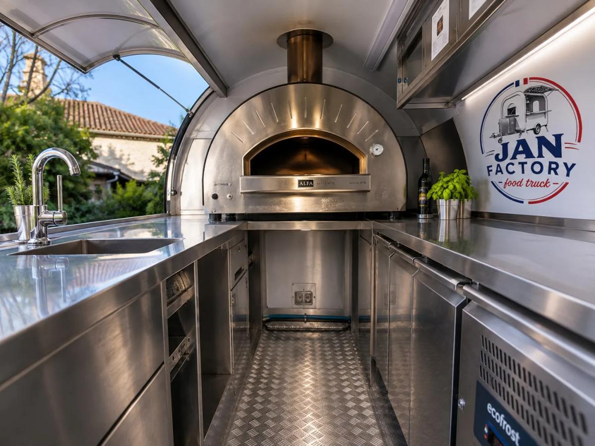 Intérieur de la XL-340 pizzeria : four à pizza inox, évier et plans de travail