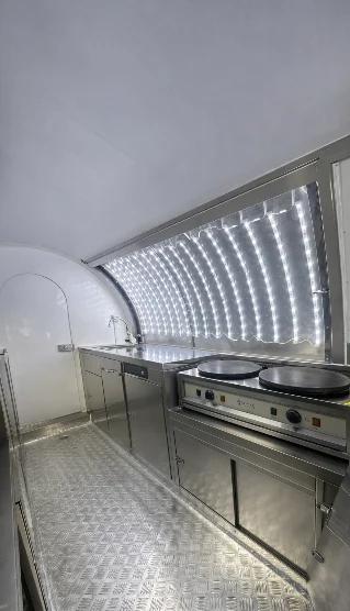 Intérieur : deux crêpières sur un meuble inox, plan de travail et évier