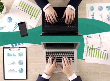Image of people using laptops, collaborating at a desk.