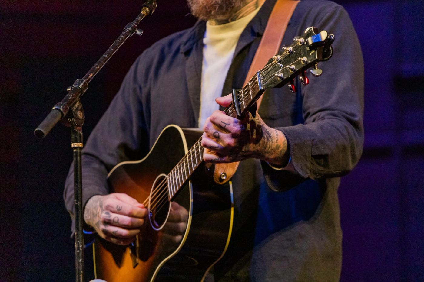Ben Fuller leading worship with guitar at Teen Challenge event after sharing testimony of identity in Christ and freedom from addiction