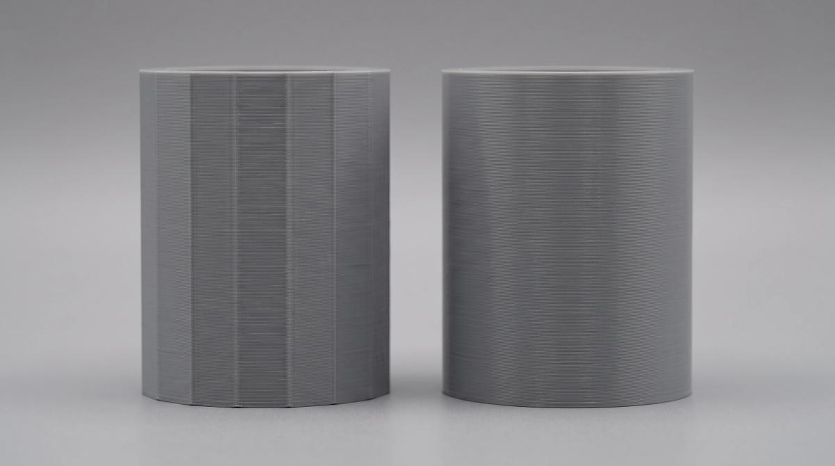 Two identical printed cylinders, one visibly faceted from a coarse export tolerance and one smoothly rounded