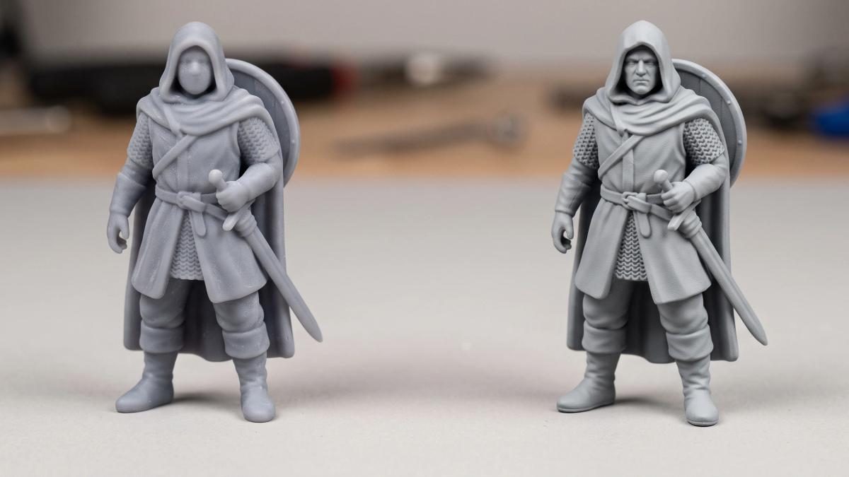 wo identical grey miniatures side by side, one with softened details from sanding and one with crisp details after filler primer