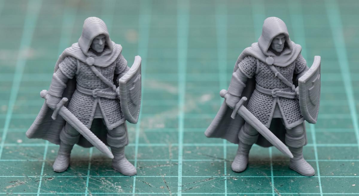 Two identical grey miniatures side by side, the left printed with a 0.4 mm nozzle and the right with a 0.2 mm nozzle showing finer detail