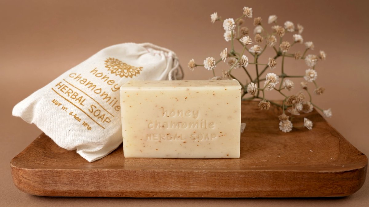 A variety of soap products photographed together on a wood tray.