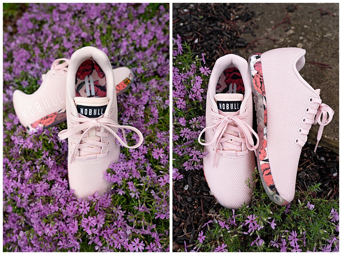 a pair of pink athletic shoes with floral soles in a bed of phlox