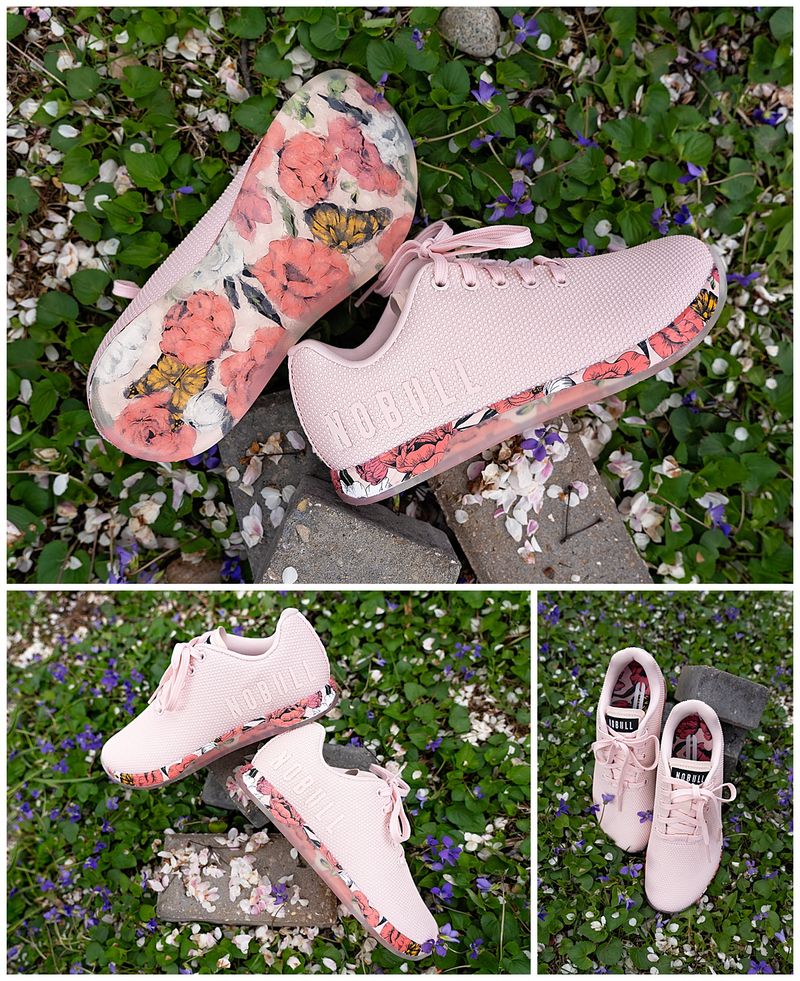 pink athletic shoe with a floral and butterfly sole in a bed of violets