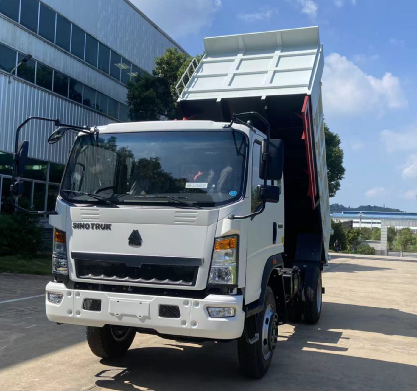 White HOMAN 4×2 tipper with its body raised