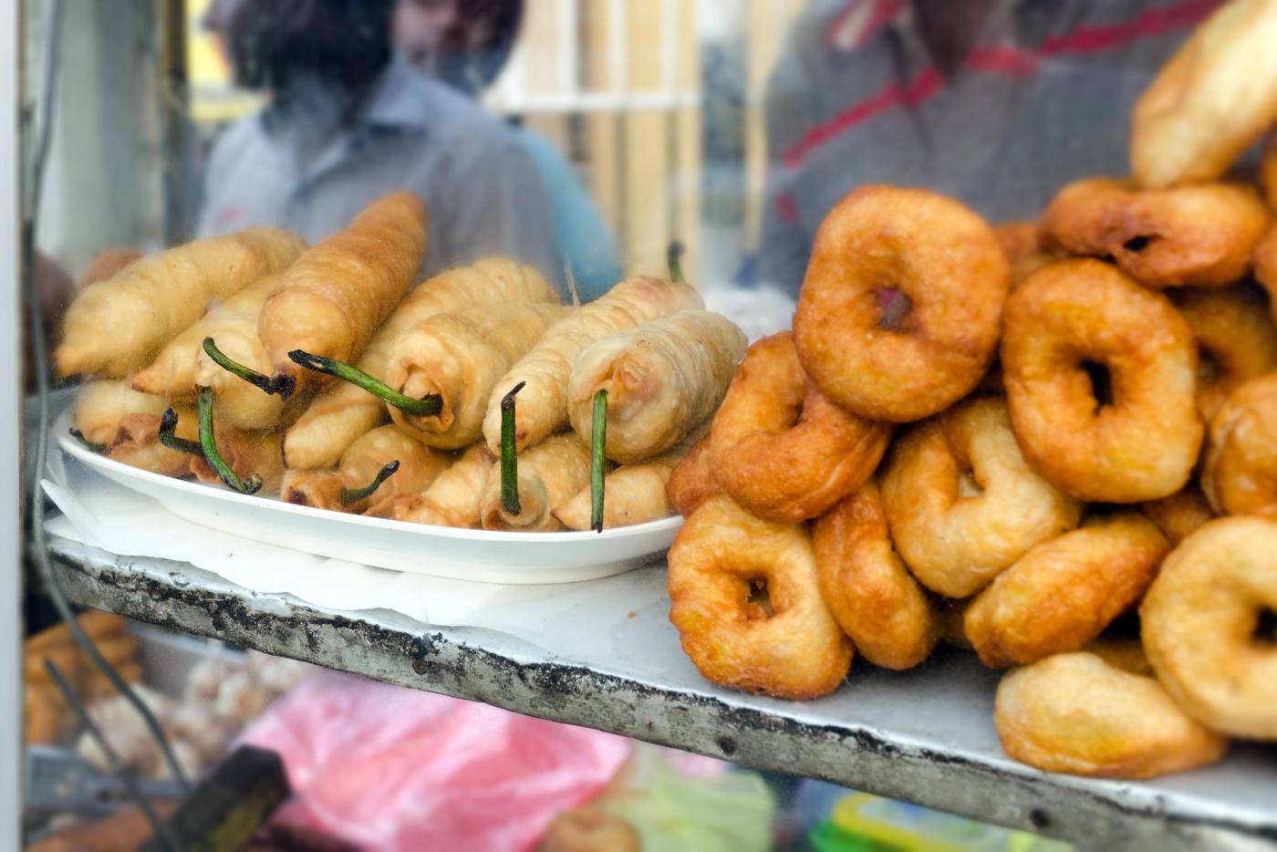 Vadai and rolls stacked in a short-eats cabinet
