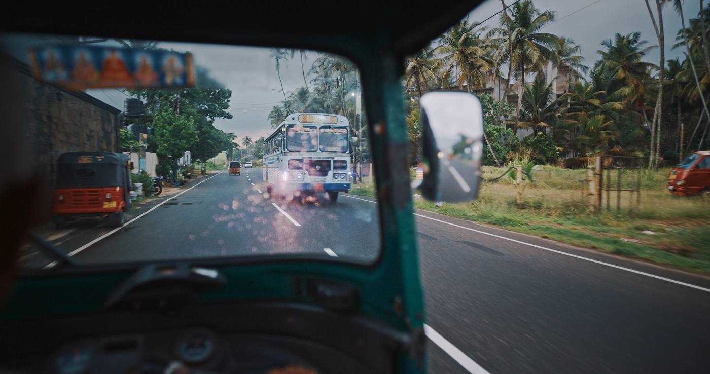 The road ahead through a tuk-tuk windscreen, a Sri Lankan bus coming the other way