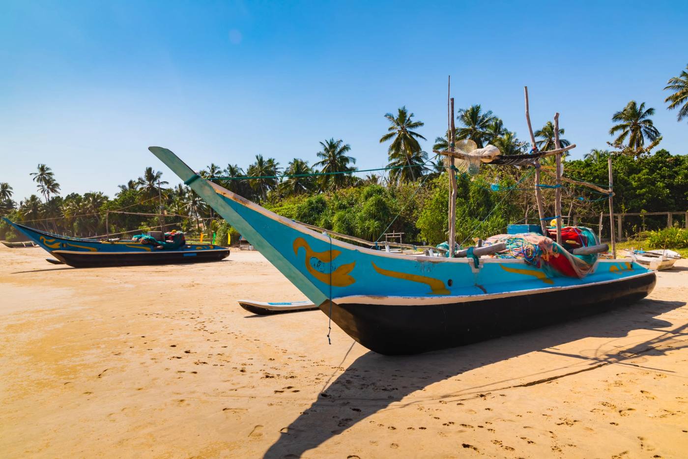 A painted oruwa fishing boat drawn up on the sand