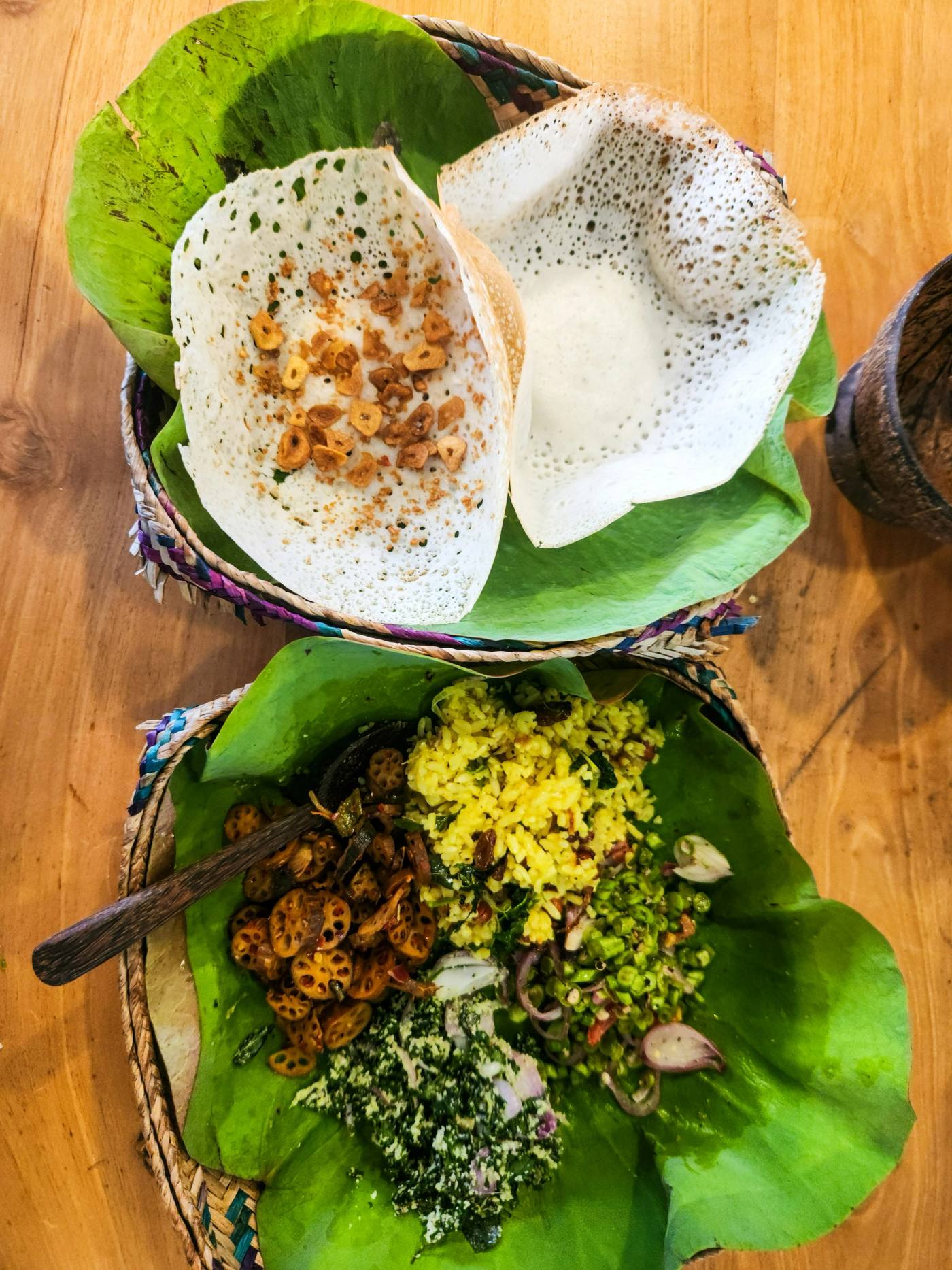 A Sri Lankan breakfast of hoppers and sambols laid out on platters