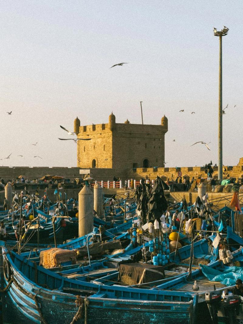 Port historique d'Essaouira avec bateaux bleus et fortifications, Maroc