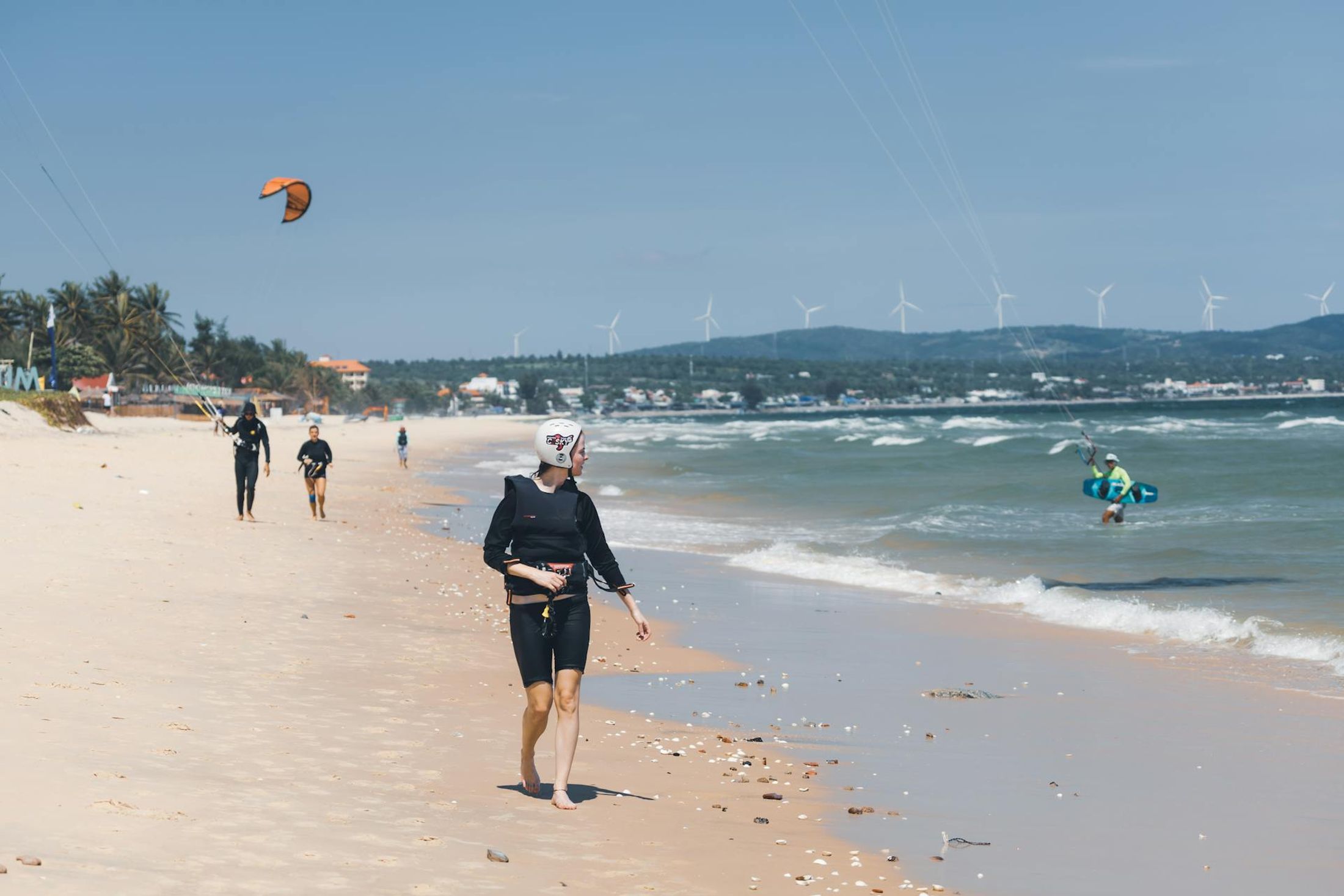 Kitesurfeurs et éoliennes sur la plage de Mui Ne, Vietnam
