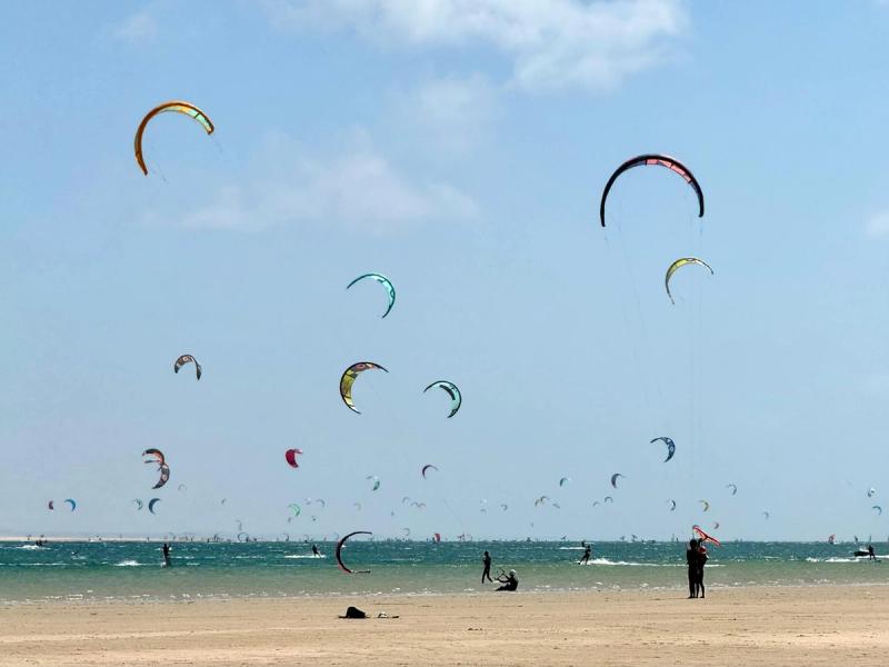 Kiteboarders et kites colorés sur la plage de Dakhla, Maroc