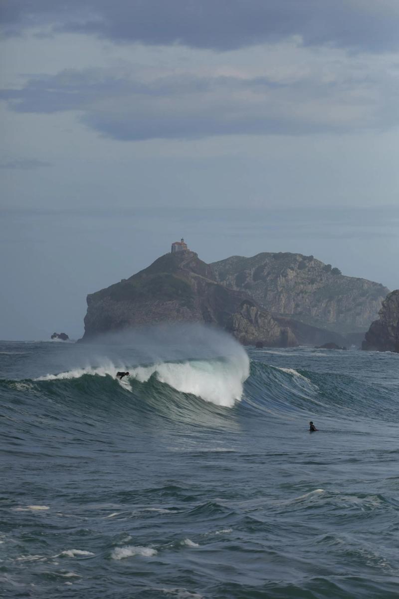 Surfeurs sur les vagues près de Gaztelugatxe, Pays Basque