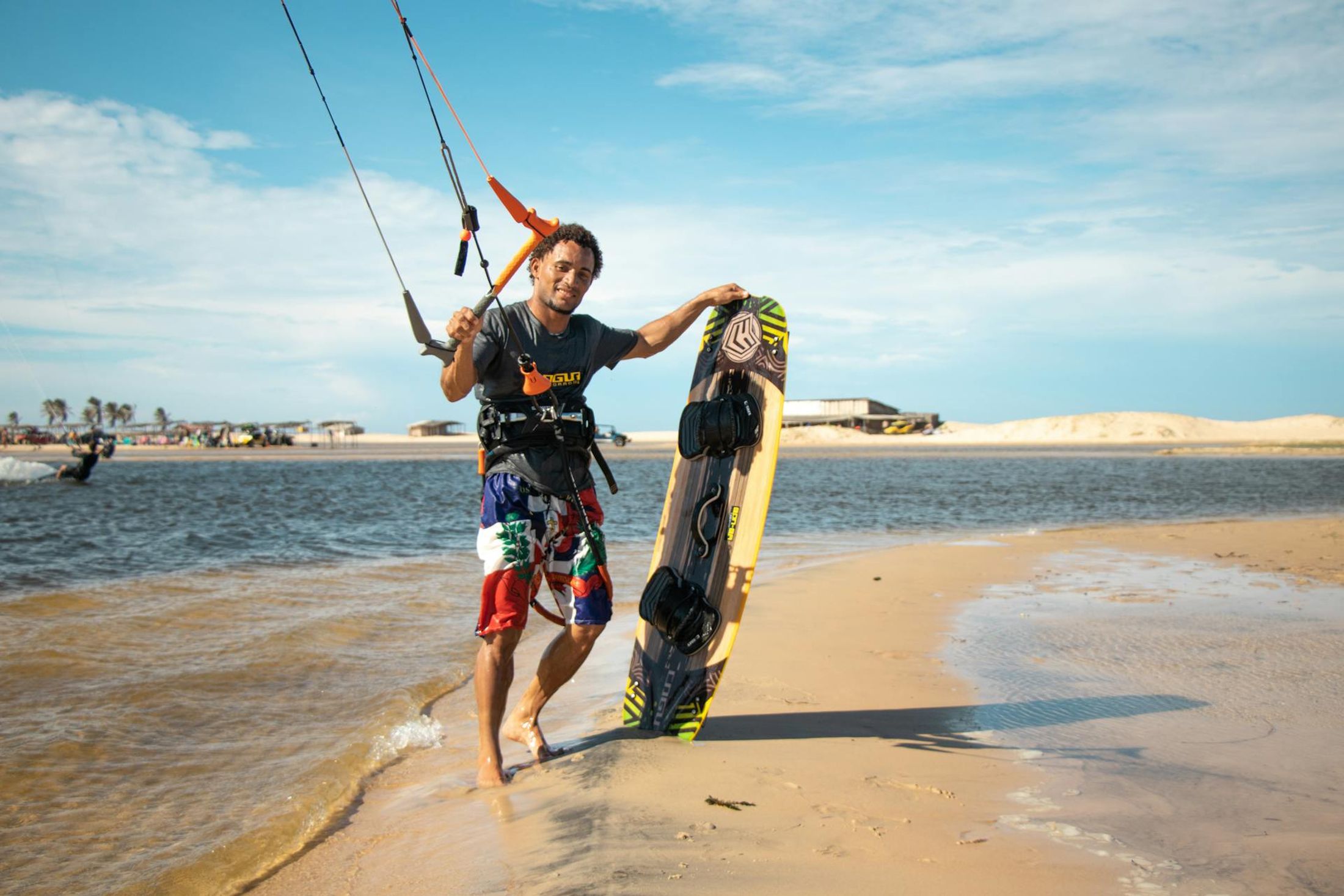 Rider tenant son kiteboard sur la plage de Jericoacoara, Brésil