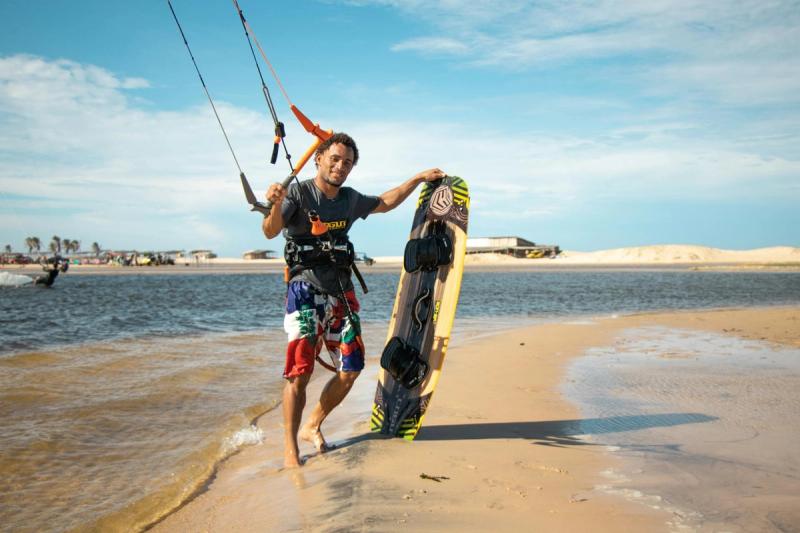 Rider tenant son kiteboard sur la plage de Jericoacoara, Brésil