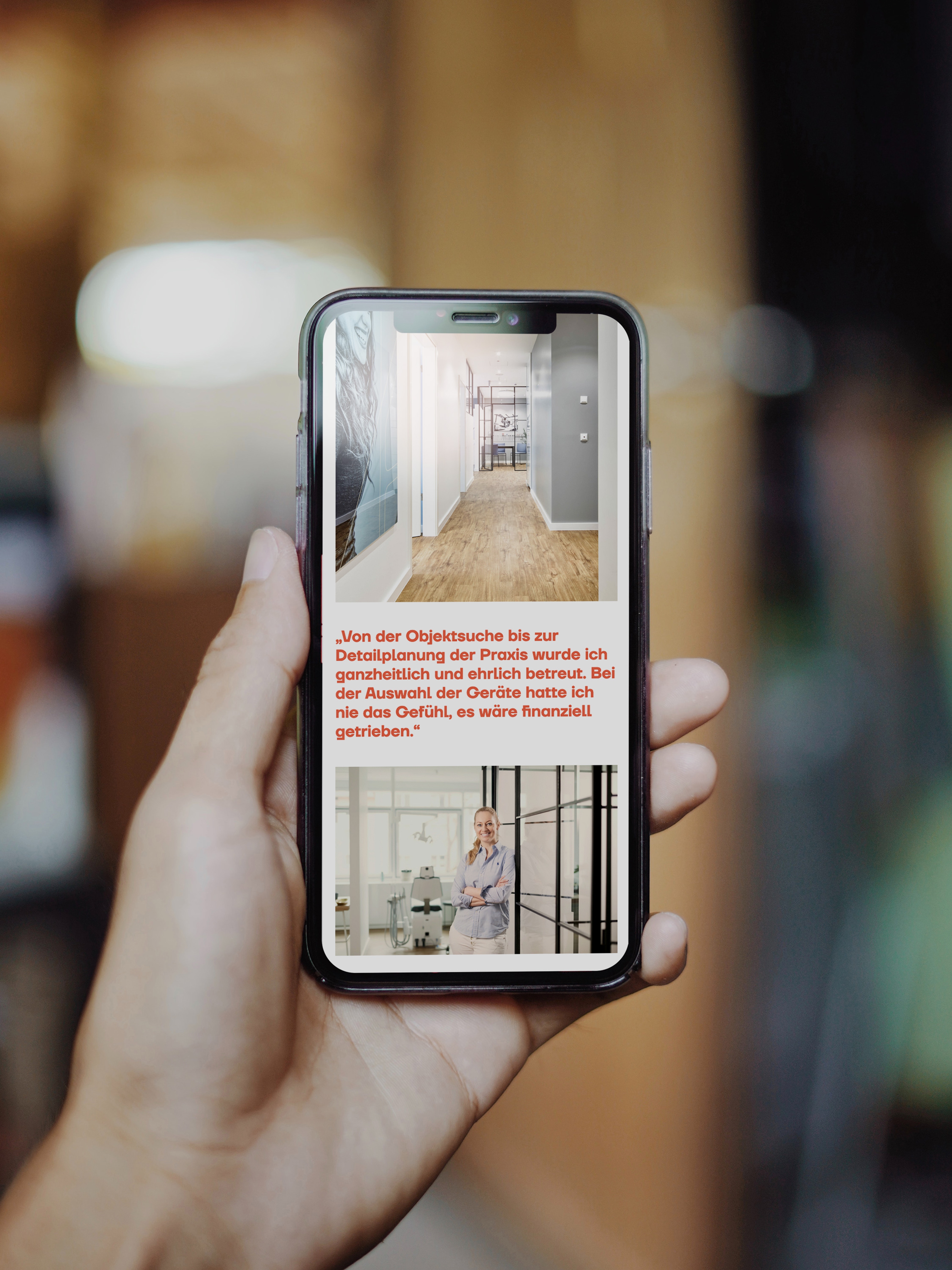 Image of a person holding a smartphone with a mockup of the website layout