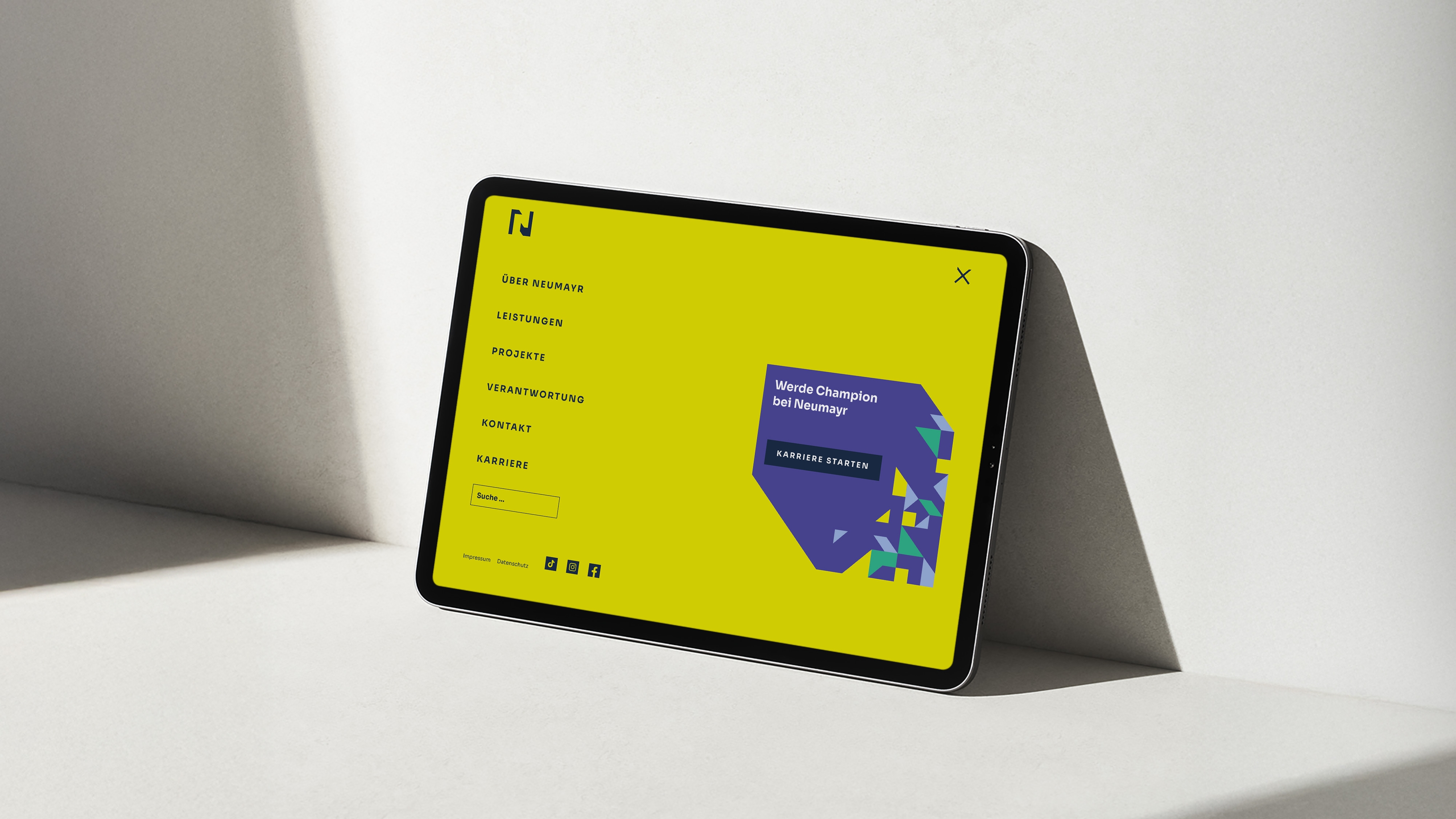 Tablet mit Neumayr Website: Navigation in Gelb mit Menü mit Störer