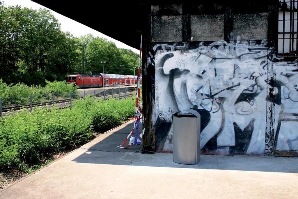 sauberer Kendo-Behälter vor einer Graffiti-Wand an einem bahnhof