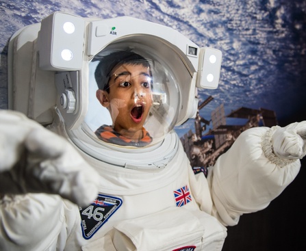 A child taking part in a space suit activity