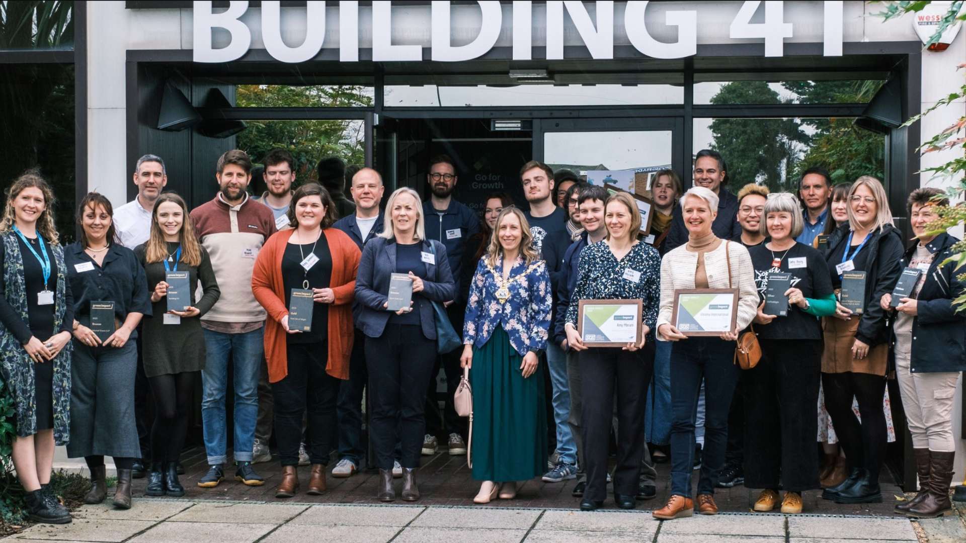 Group of people with their Green Impact 2023 awards outside of Building 41 in Cowes on the Isle of Wight
