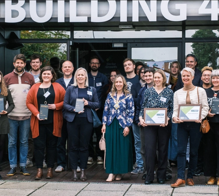 Group of people with their Green Impact 2023 awards outside of Building 41 in Cowes on the Isle of Wight
