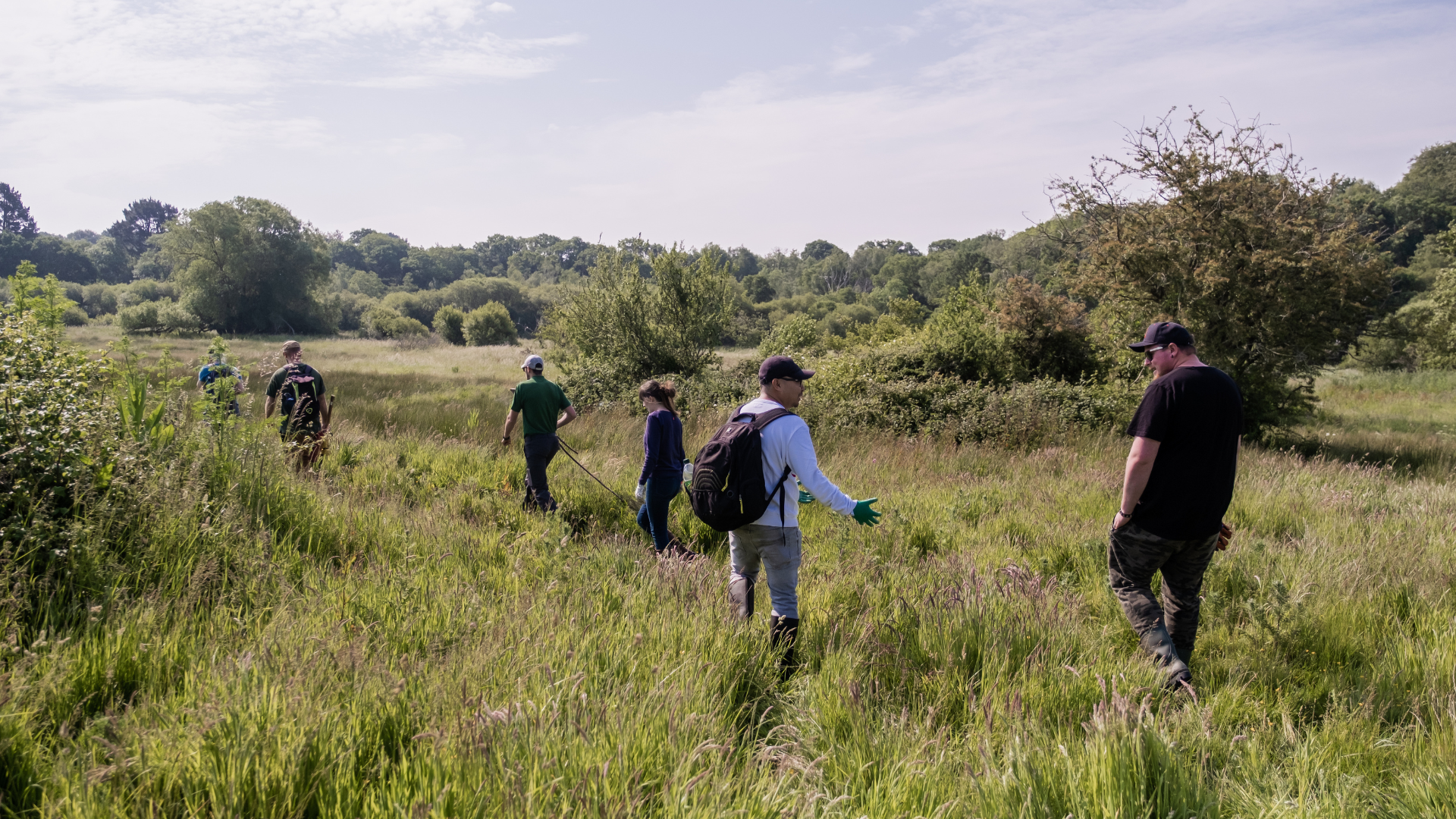 NOSY team volunteering for the Hampshire & IOW Wildlife Trust in a field, balsam pulling 