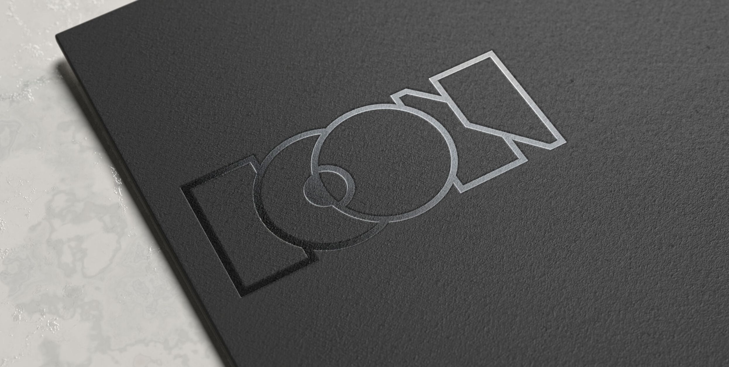 AOP ICON logo embossed in silver foil on textured black card, with bold geometric lettering.