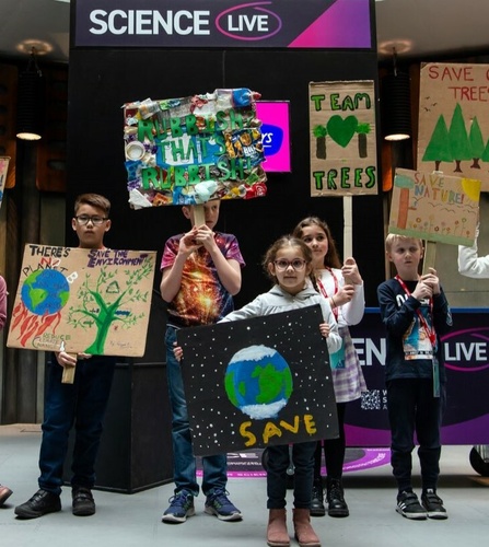 A group of children holding banners with "save our trees" messages