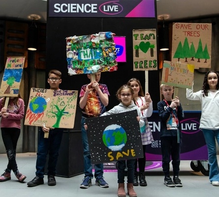 A group of children holding banners with "save our trees" messages