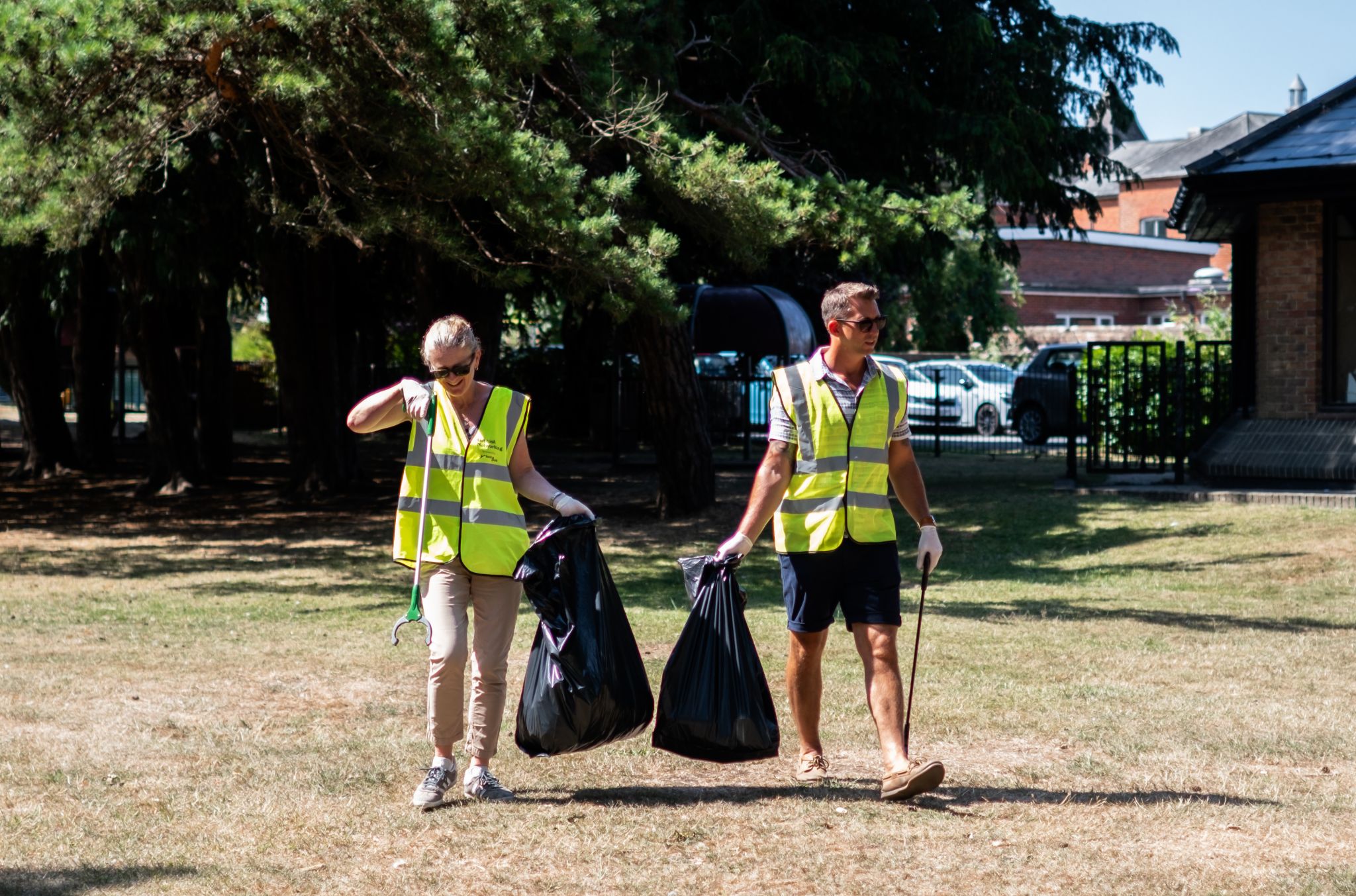 NOSY team member taking part in a local community litter pick event wearing hi-vis vests and collecting rubbish.