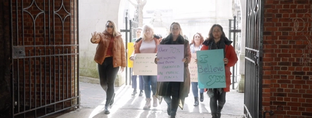 A group of women marching in protest of violence against women and girls