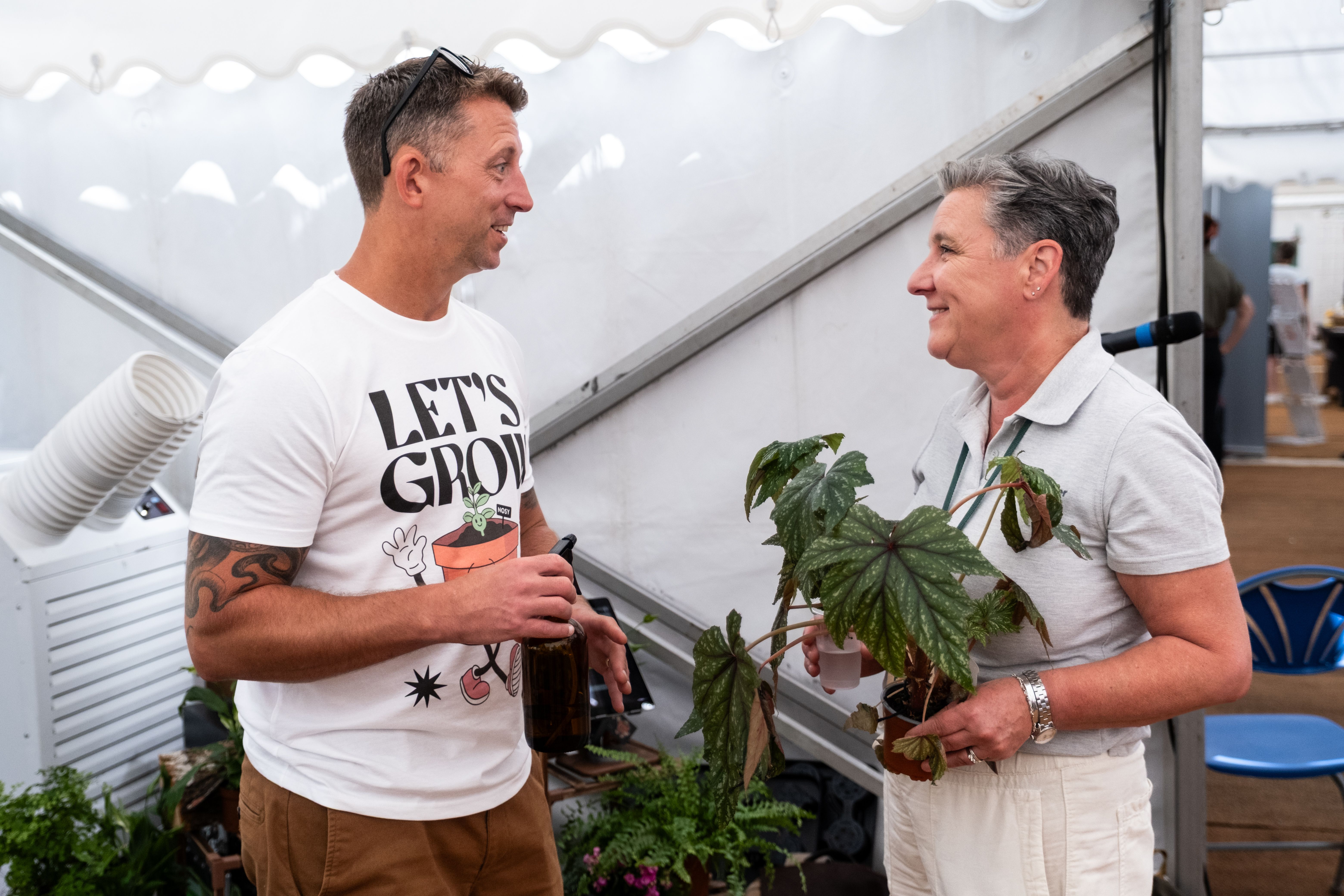  convo-2025.jpg NOSY team member chatting with an attendee holding a potted plant at the Chamber Expo