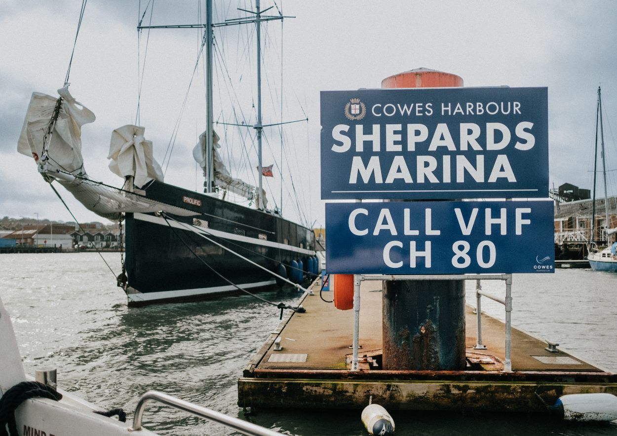 Cowes Harbour Shepards Marina sign with sailing vessel in background