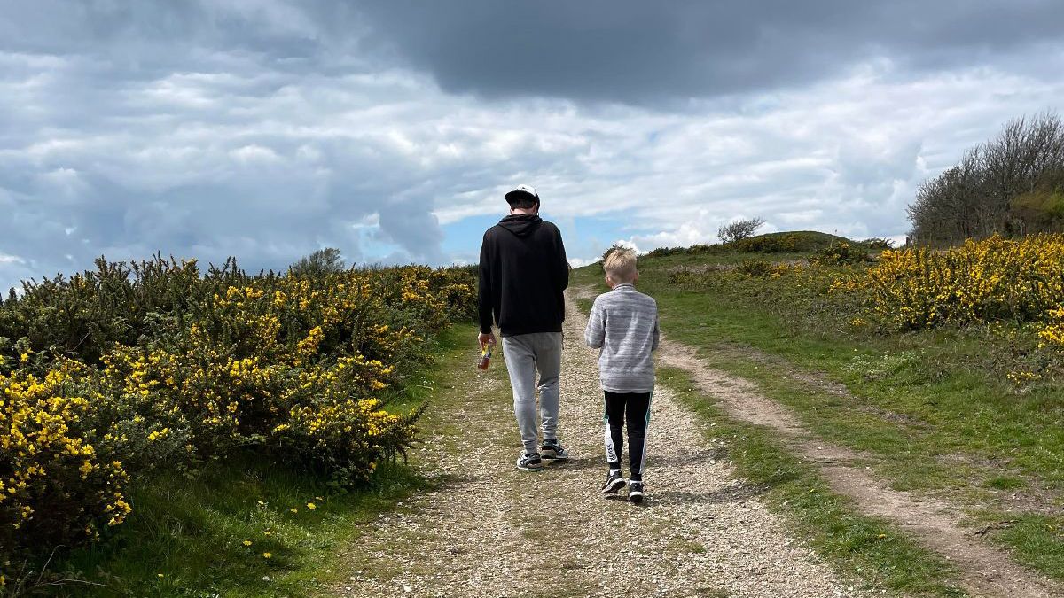'Walk for Wildlife' over a background of an individual walking through the woods. Featuring the Hampshire & Isle of Wight Wildlife Trust logo