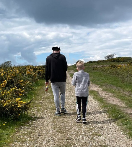 'Walk for Wildlife' over a background of an individual walking through the woods. Featuring the Hampshire & Isle of Wight Wildlife Trust logo