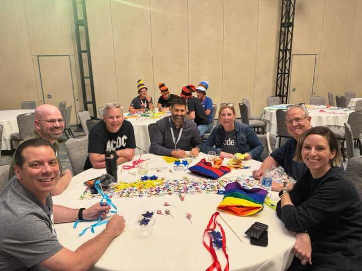 Kscope25 attendees collaborating around a table.
