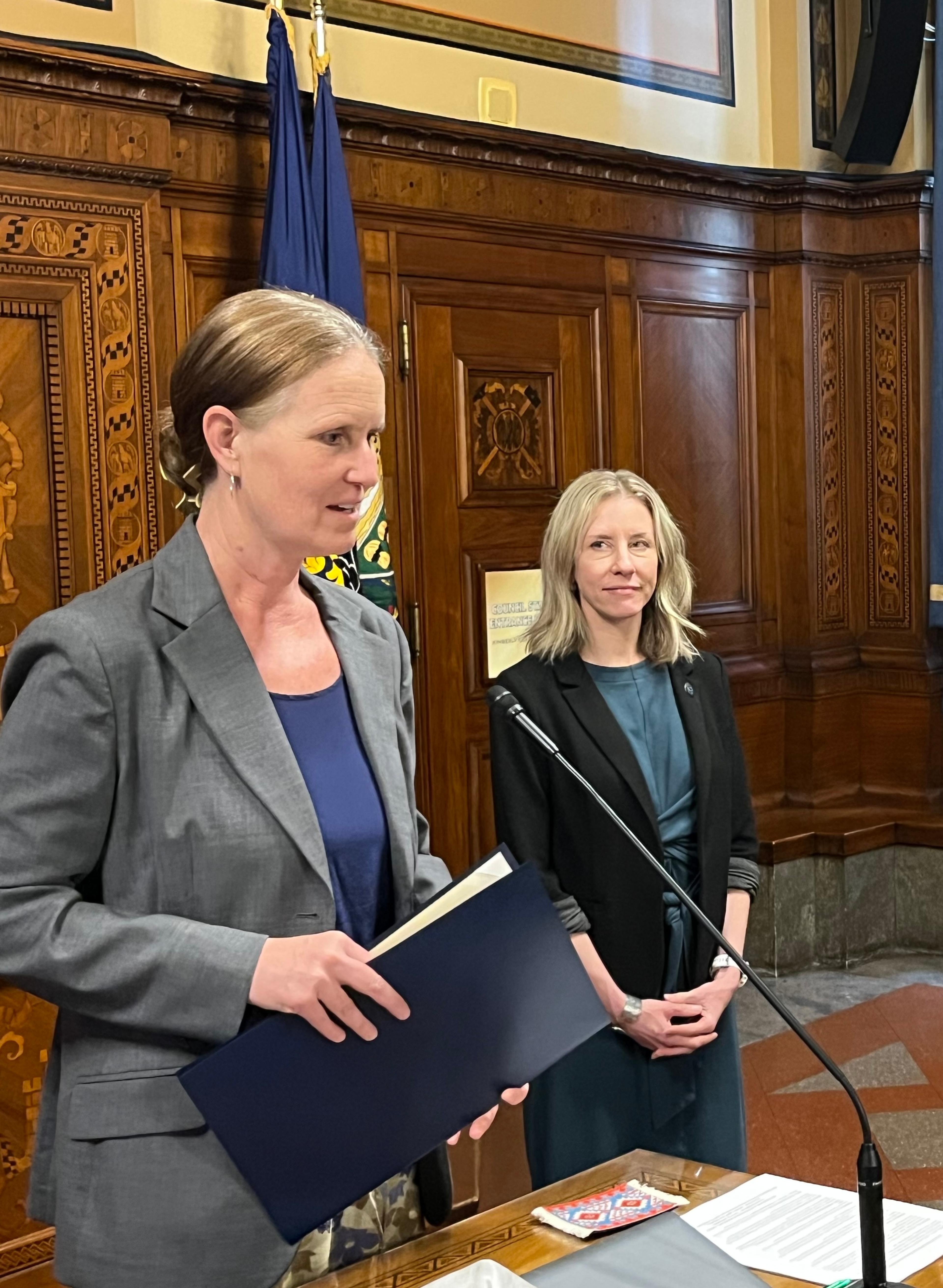 Councilmember Barb Warwick offers remarks at podium in City Hall and presents Friendship Circle with City Proclamation